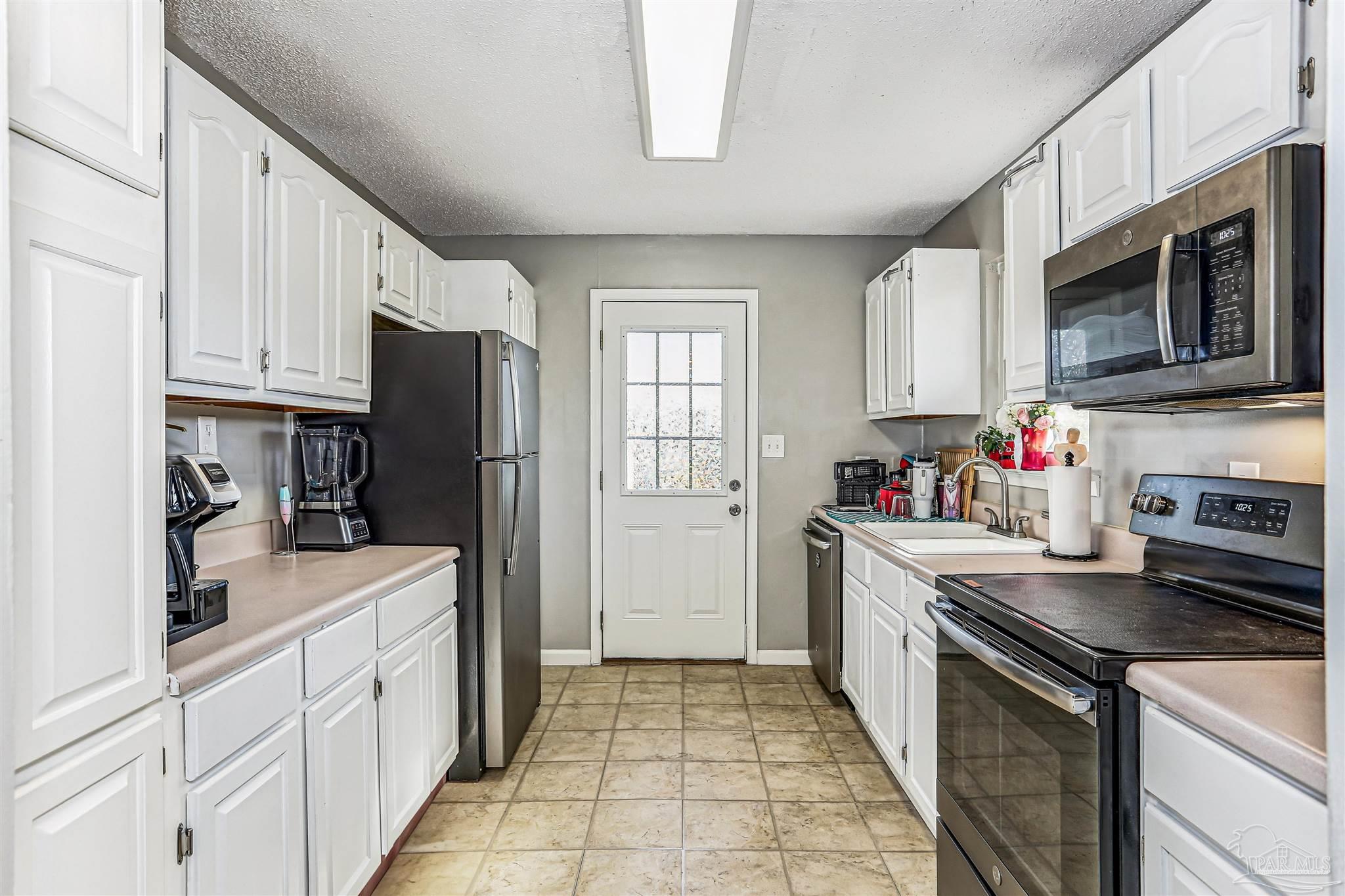 6810 Myra Road Molino, FL 32577 - Photo 13 of 20 a kitchen with stainless steel appliances granite countertop a refrigerator stove microwave and sink
