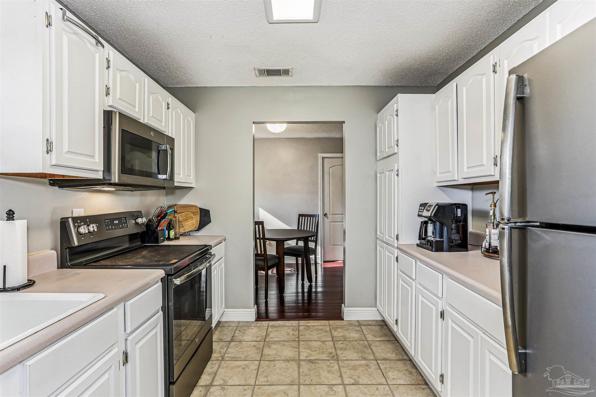 6810 Myra Road Molino, FL 32577 - Photo 15 of 20 a kitchen with white cabinets and appliances
