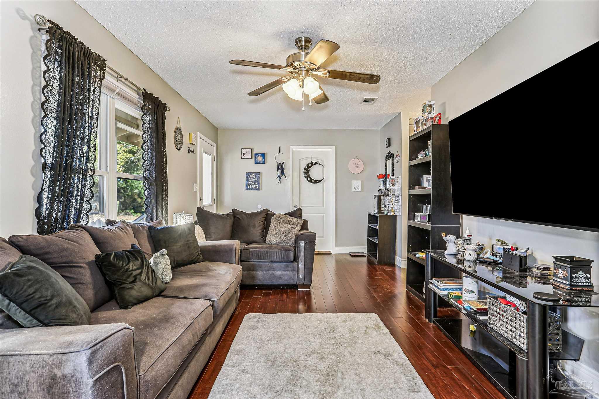 6810 Myra Road Molino, FL 32577 - Photo 8 of 20 a living room with furniture a flat screen tv and a window