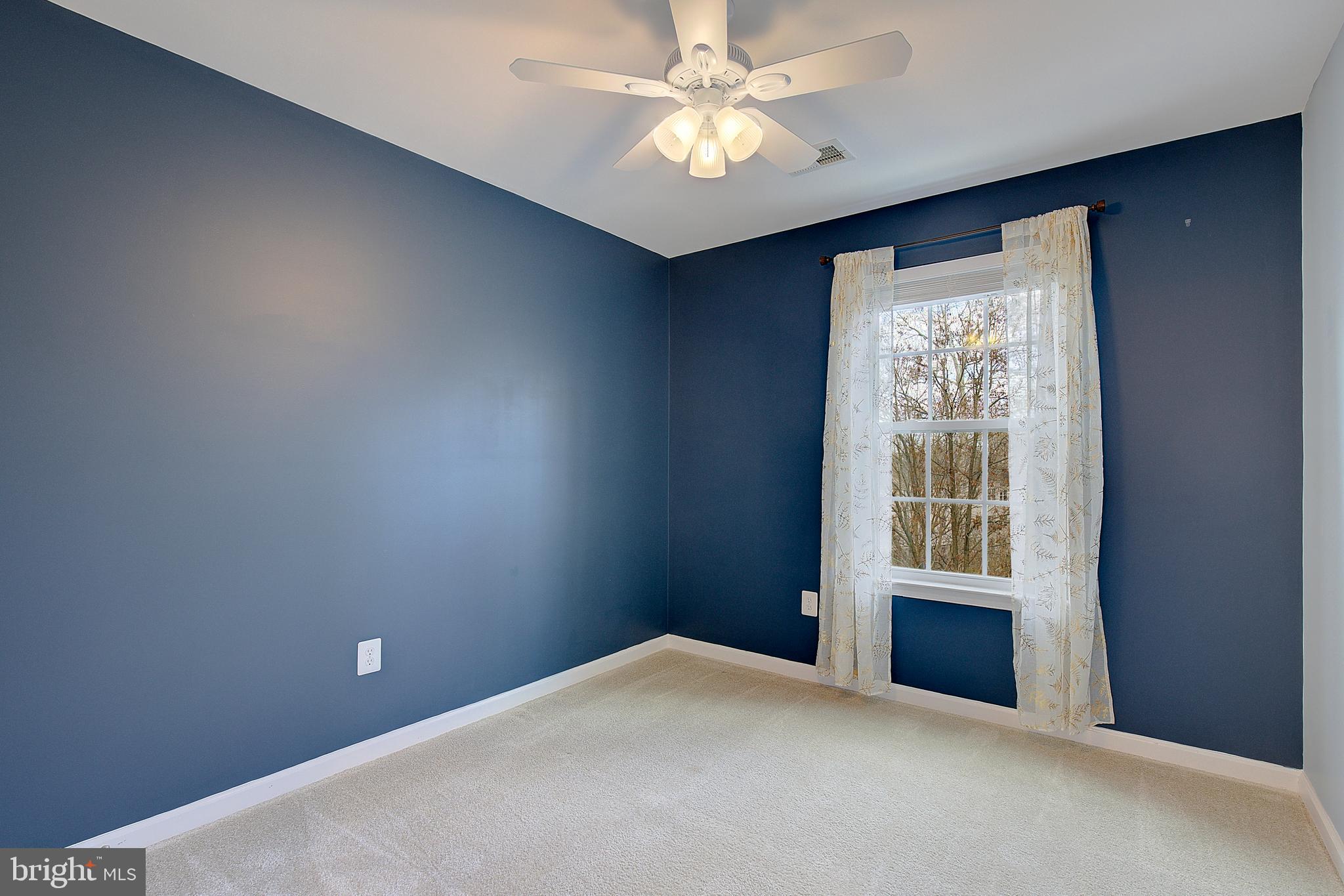 8410 Clear Spring Drive, Unit 1 Chesapeake Beach, MD 20732 - Photo 15 of 41 an empty room with windows and fan