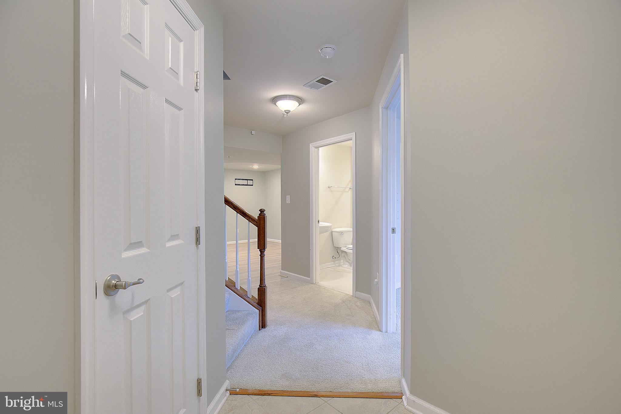 8410 Clear Spring Drive, Unit 1 Chesapeake Beach, MD 20732 - Photo 2 of 41 a view of a hallway with windows and stairs