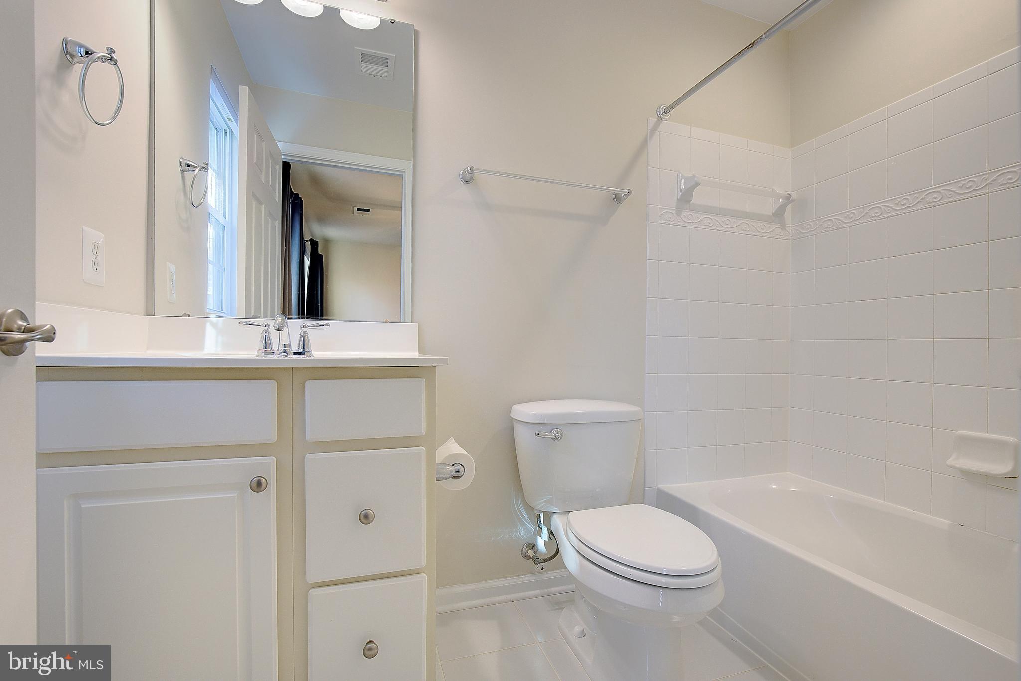 8410 Clear Spring Drive, Unit 1 Chesapeake Beach, MD 20732 - Photo 26 of 41 a white toilet sitting next to a bathroom sink and vanity