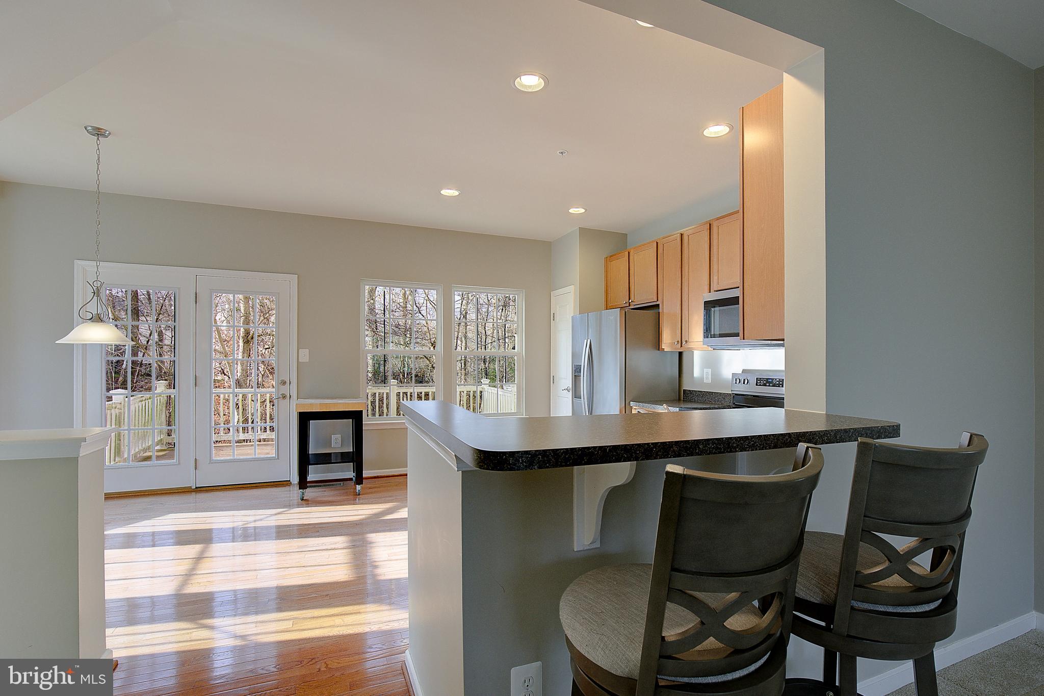 8410 Clear Spring Drive, Unit 1 Chesapeake Beach, MD 20732 - Photo 10 of 41 a kitchen with a table chairs stove and cabinets