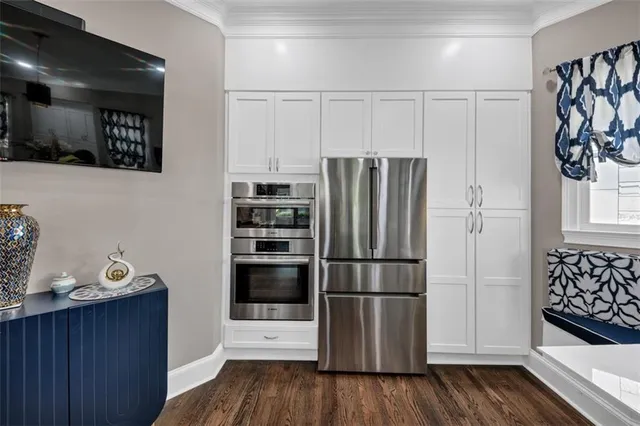a living room with stainless steel appliances furniture and a large window