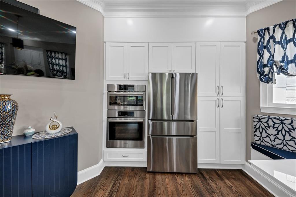 526 Hill Street Southeast Atlanta, GA 30312 - Photo 17 of 81 a kitchen with stainless steel appliances wooden floor and cabinets