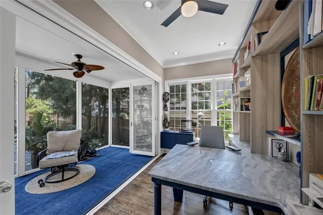 an empty room with wooden floor chandelier fan and windows