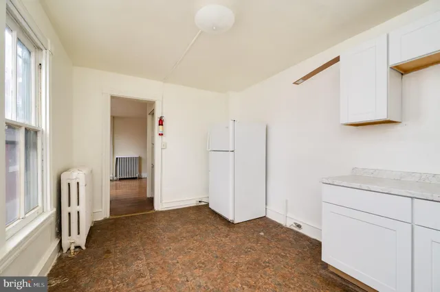 a view of empty room with window and cabinet