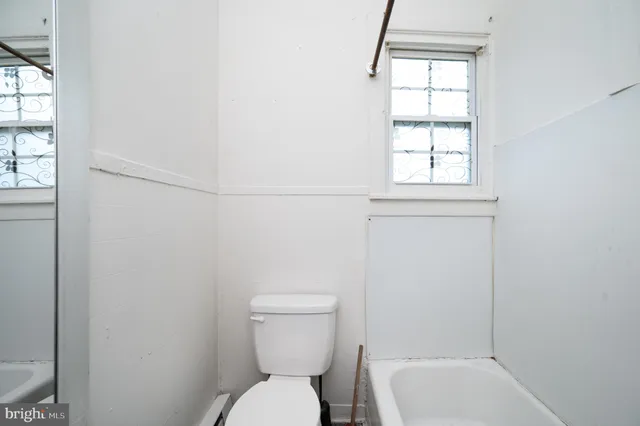 a bathroom with a toilet a sink and mirror