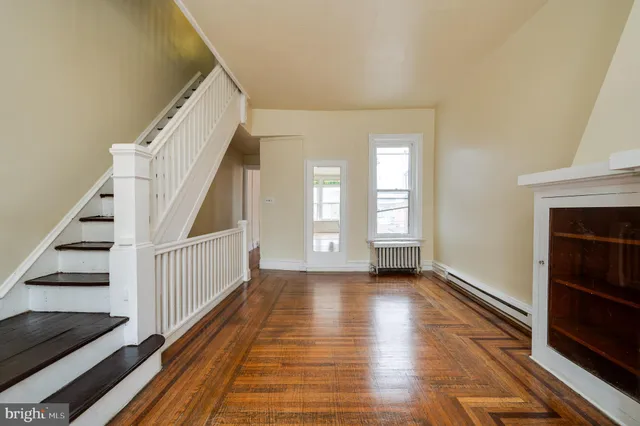 a view of a livingroom with wooden floor and staircase