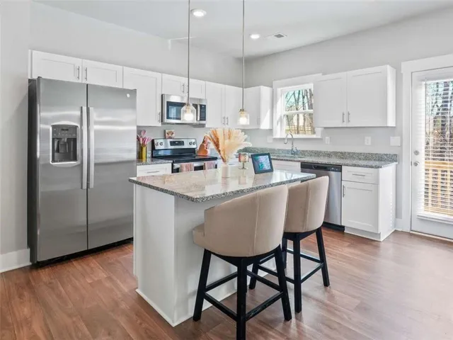 a kitchen with stainless steel appliances granite countertop a sink stove and cabinets