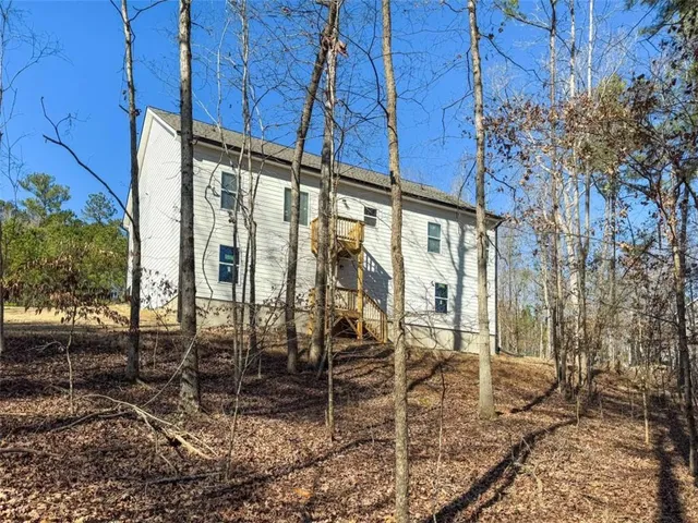 a view of a yard with plants and wooden fence