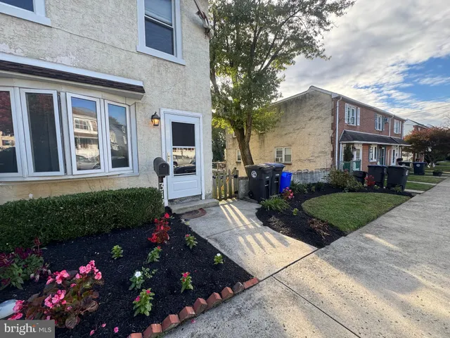a view of a house that has a lot of flower plants