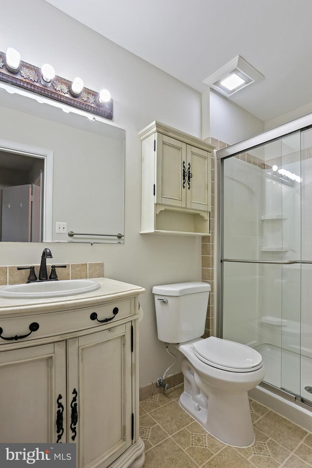 15504 Williston Road Silver Spring, MD 20905 - Photo 20 of 41 a bathroom with a toilet a sink a mirror and vanity