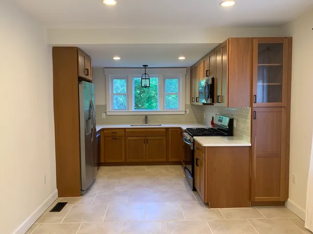a kitchen with stainless steel appliances granite countertop a refrigerator and a sink