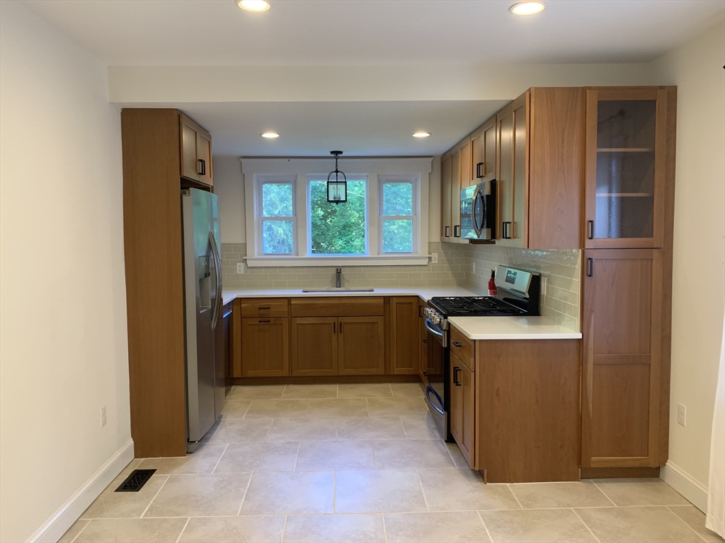 140 Ames Street, Unit 1 Sharon, MA 02067 - Photo 4 of 16 a kitchen with stainless steel appliances granite countertop a refrigerator and a sink