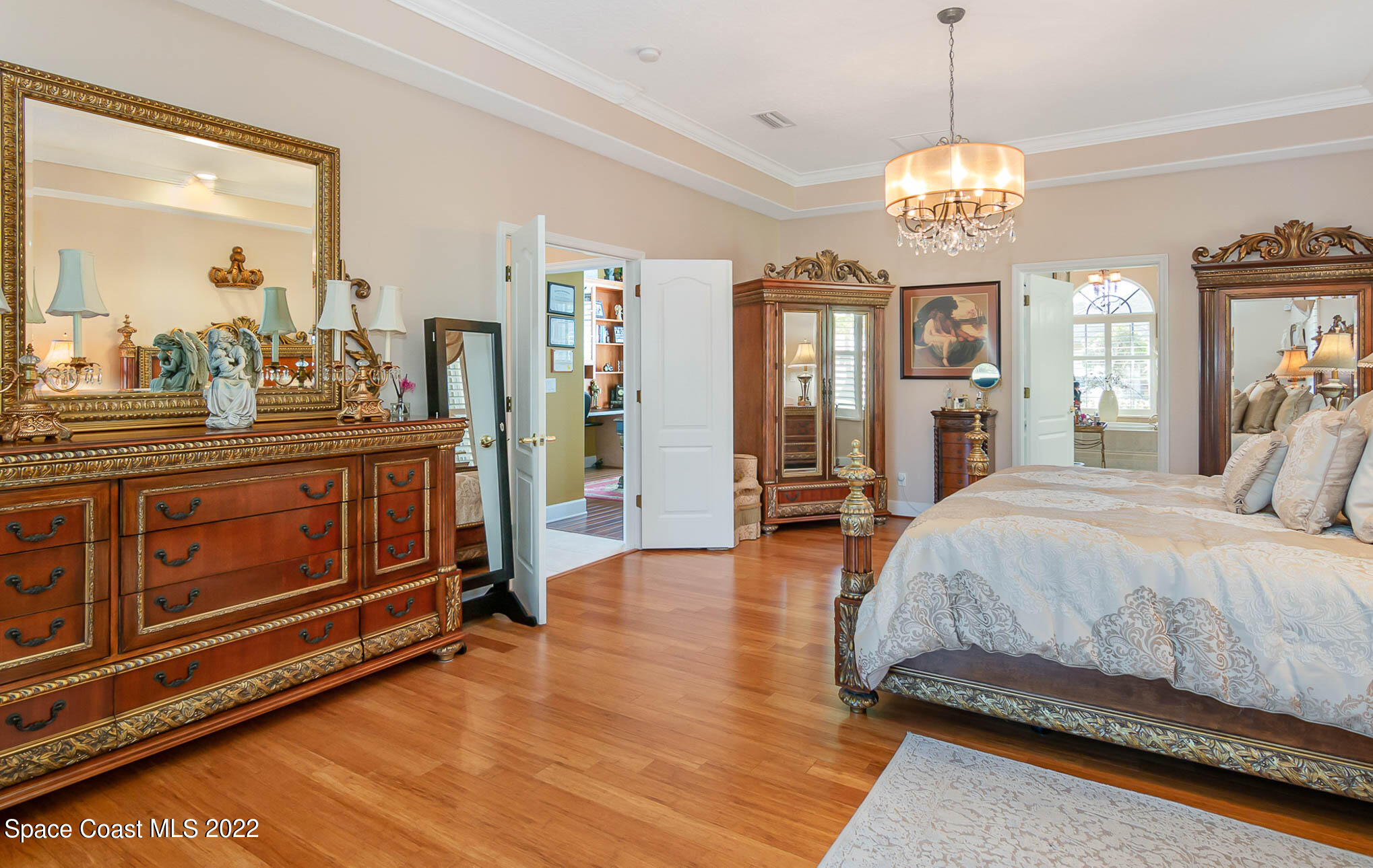 1338 Centennial Way Rockledge, FL 32955 - Photo 23 of 46 a spacious bedroom with a bed and a chandelier