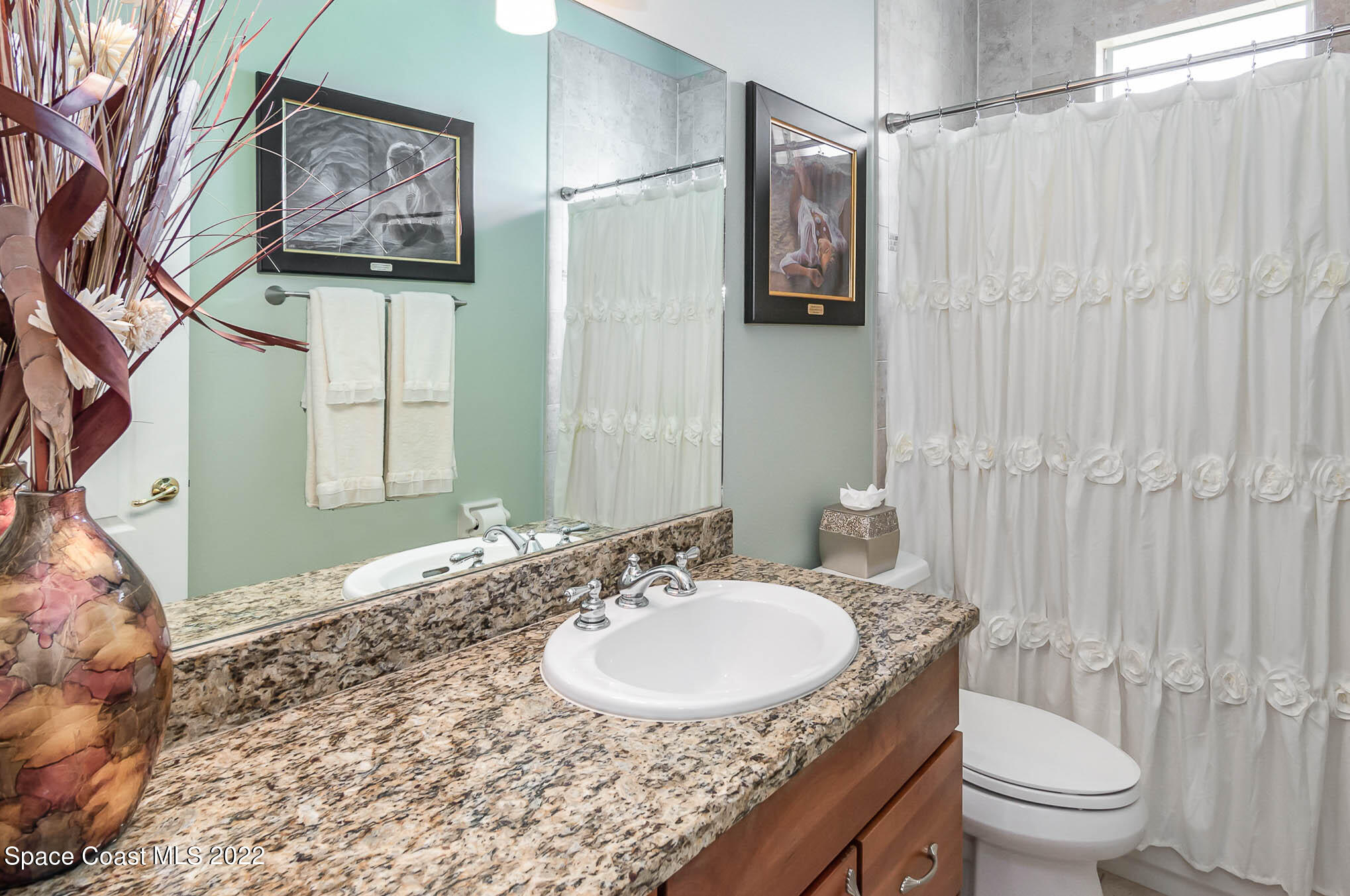 1338 Centennial Way Rockledge, FL 32955 - Photo 29 of 46 a bathroom with a granite countertop sink a toilet and a mirror