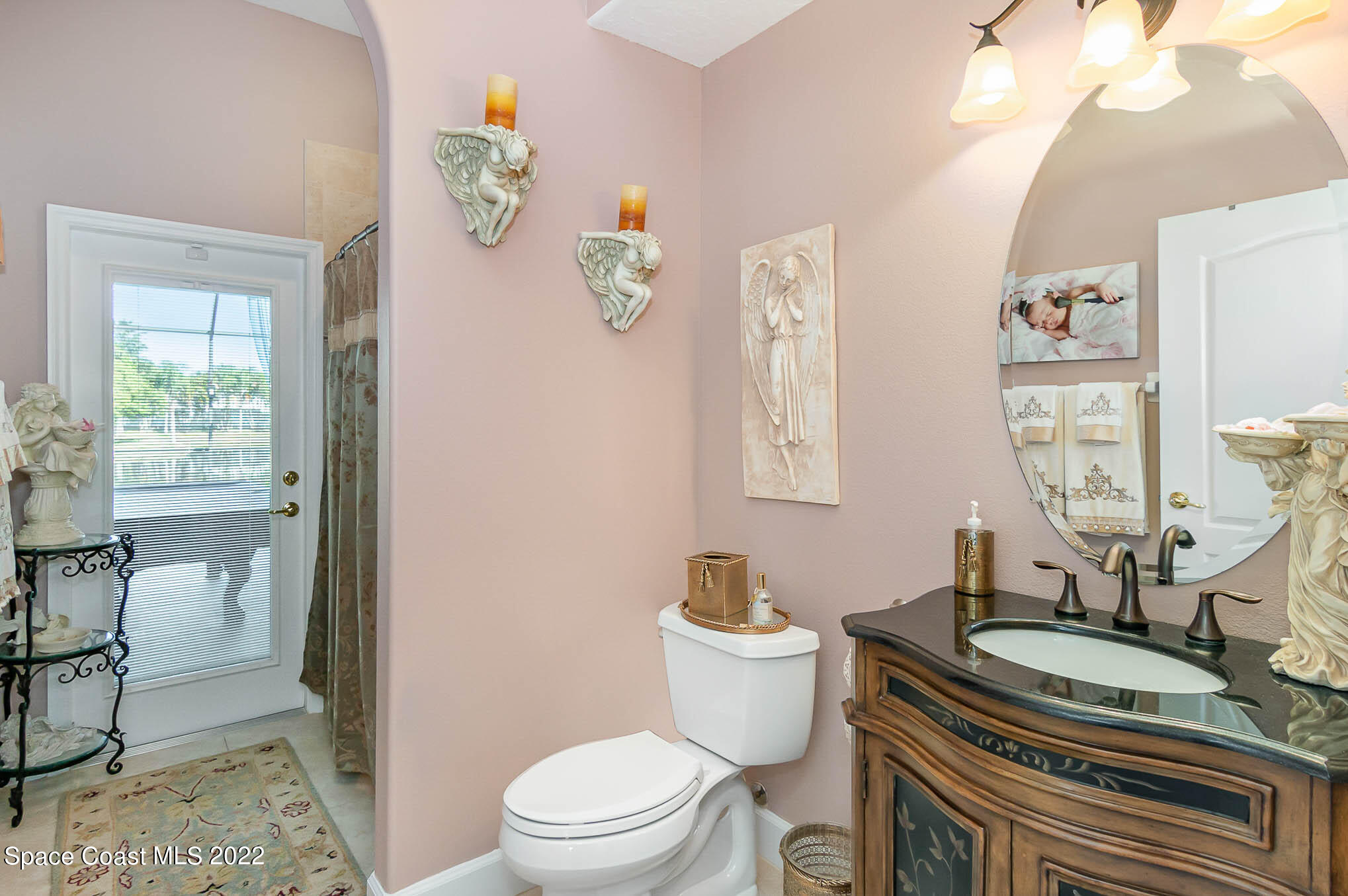 1338 Centennial Way Rockledge, FL 32955 - Photo 31 of 46 a bathroom with a granite countertop toilet a sink and a window