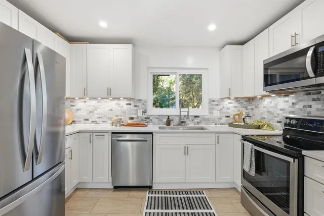 a kitchen with stainless steel appliances a sink stove and refrigerator