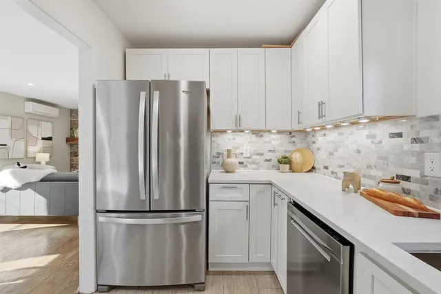 a kitchen with a refrigerator sink and cabinets