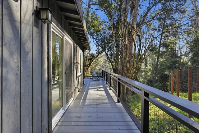 a view of balcony with wooden floor and fence