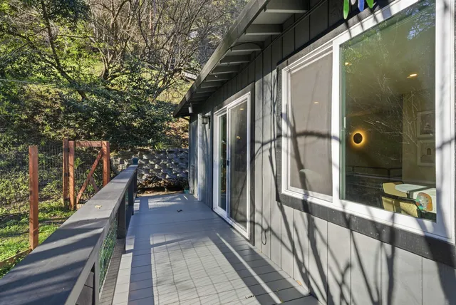 a balcony with wooden floor table and chairs