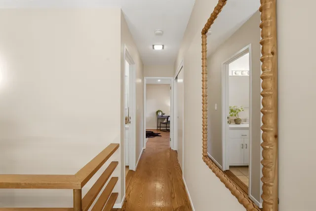 a view of a hallway with wooden floor and staircase