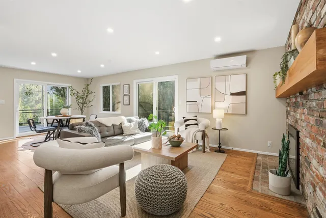 a living room with furniture fireplace and a large window