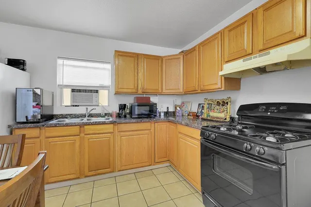 a kitchen with stainless steel appliances a stove a sink cabinets and a dining table