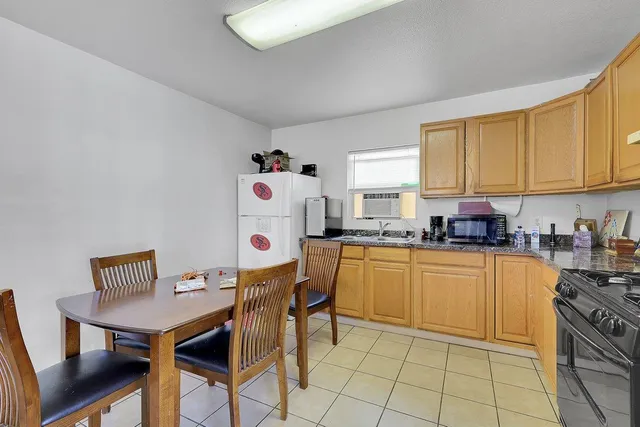 a kitchen with a table chairs stove and refrigerator