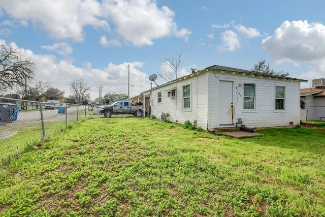 a view of a big house with a big yard and large tree