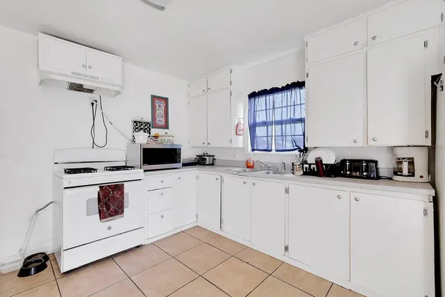 a kitchen with white cabinets sink and white appliances