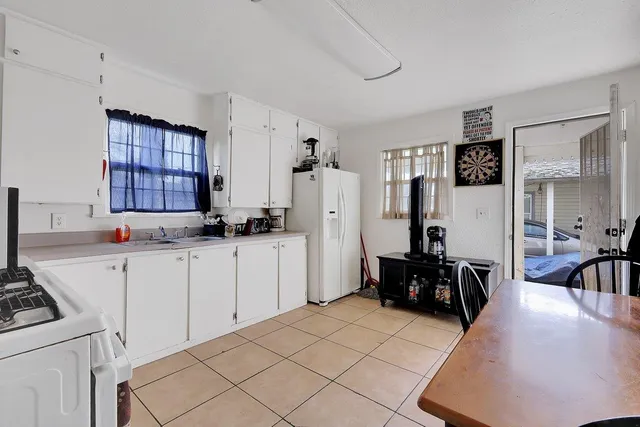 a kitchen with a refrigerator and white cabinets