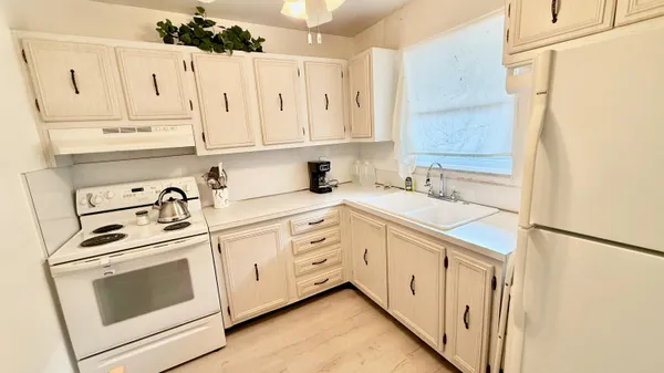 a kitchen with white cabinets and white appliances