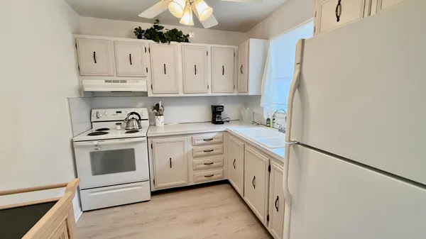 a kitchen with white cabinets and white appliances