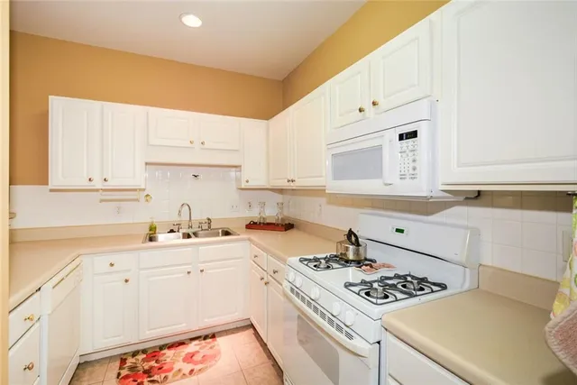 a kitchen with cabinets appliances a sink and a counter top