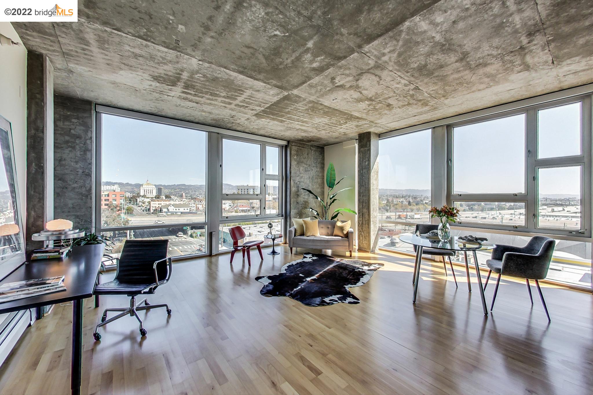 311 Oak Street, Unit 715 Oakland, CA 94607 - Photo 1 of 1 a living room with furniture large windows and wooden floor