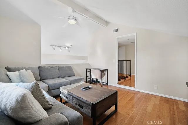 a living room with furniture and a wooden floor