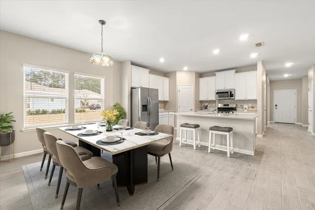 a view of a dining room and livingroom with furniture wooden floor a chandelier