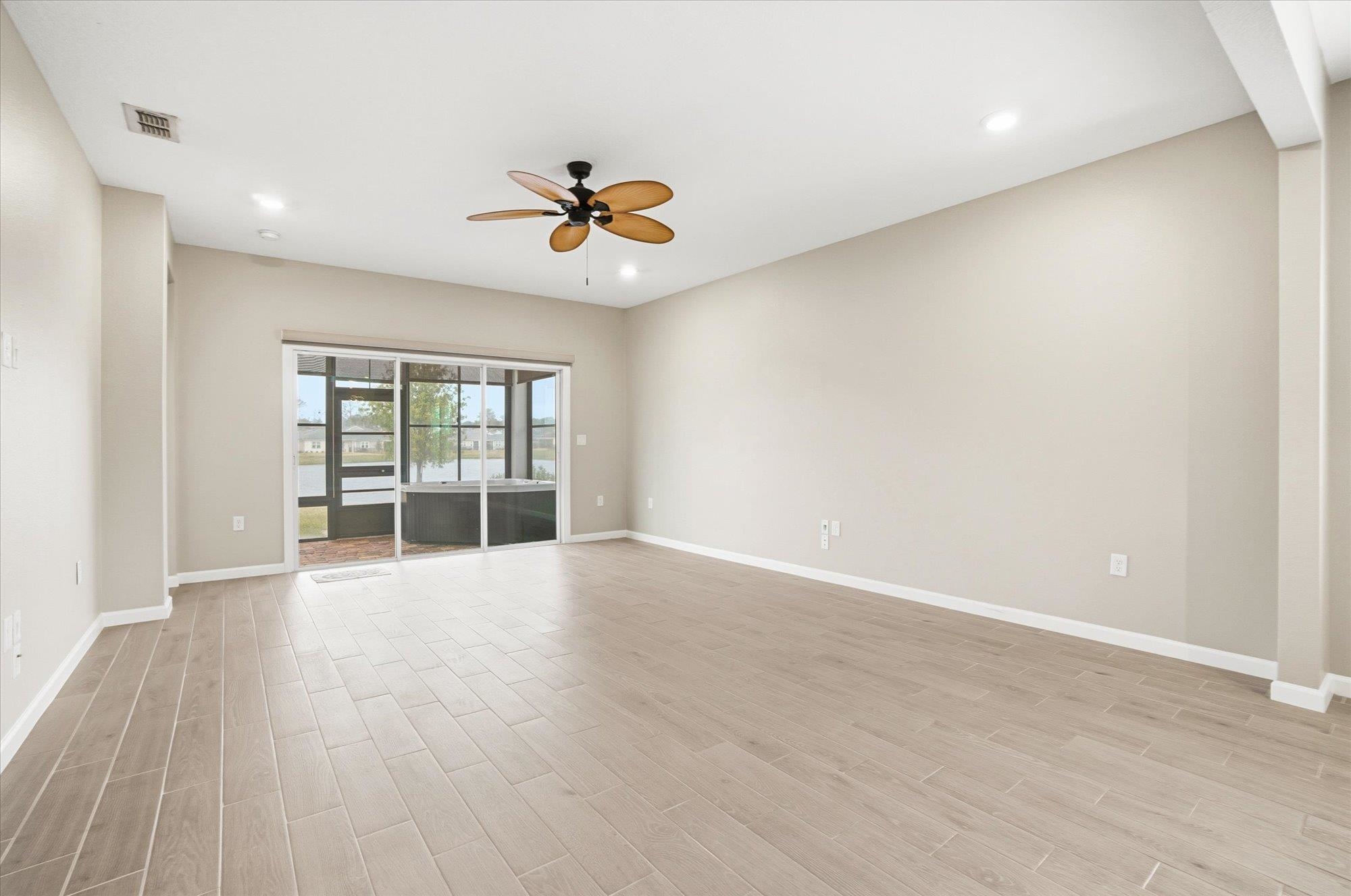 204 Field Flower Way St. Augustine, FL 32092 - Photo 19 of 60 a view of an empty room with a window and wooden floor