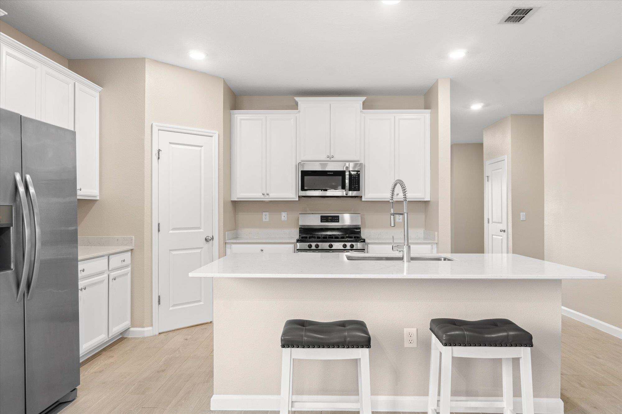 204 Field Flower Way St. Augustine, FL 32092 - Photo 4 of 60 a kitchen with stainless steel appliances granite countertop a refrigerator a sink dishwasher a stove and white cabinets with wooden floor