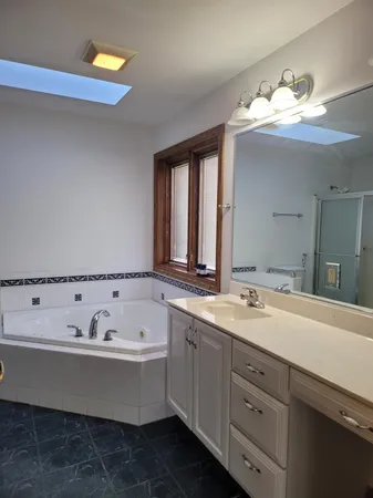 a bathroom with a tub sink and mirror