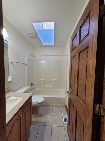 a bathroom with a granite countertop sink toilet and shower