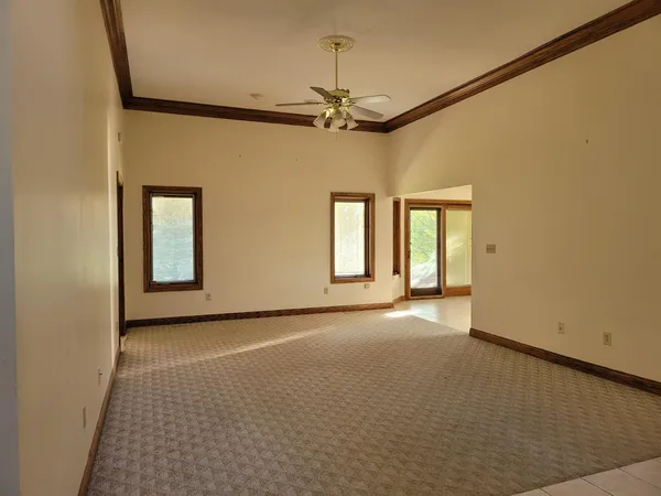 a view of a room with a ceiling fan and windows