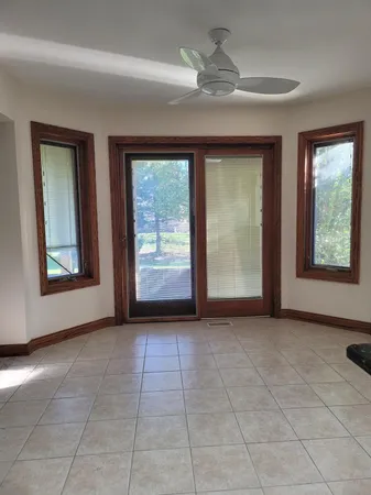 a view of an empty room with exposed radiator and a window