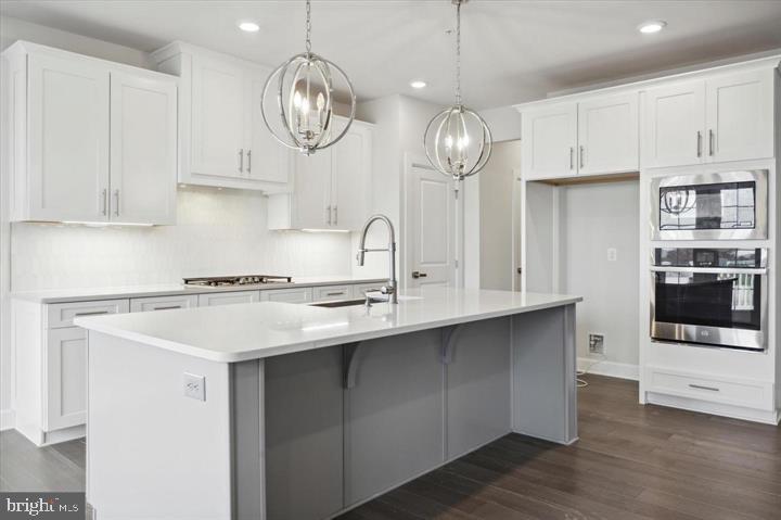 325 Piper Lane Exton, PA 19341 - Photo 8 of 24 a kitchen with kitchen island granite countertop a sink a stove and cabinets