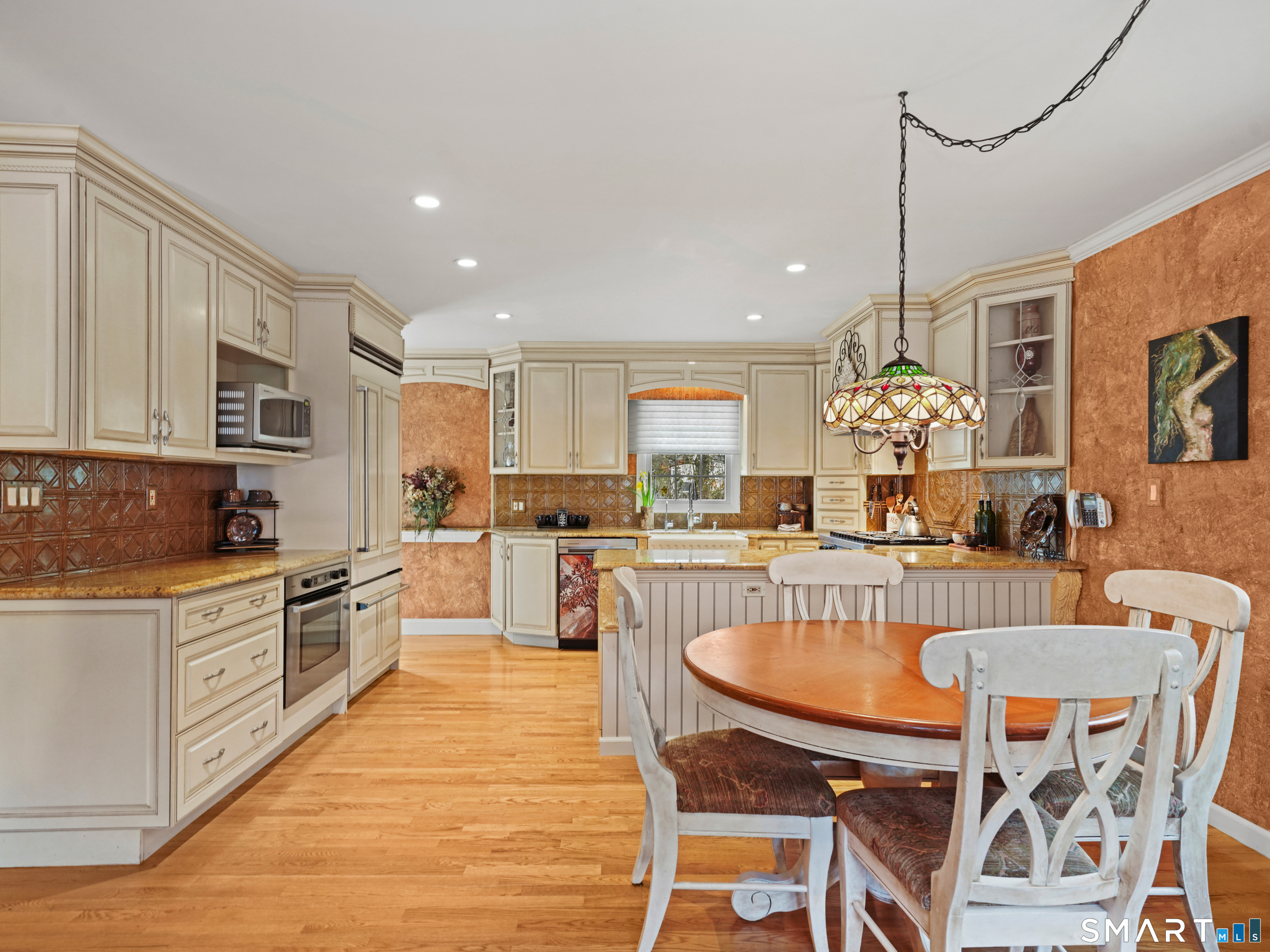 82 Ramapoo Road Ridgefield, CT 06877 - Photo 11 of 40 a kitchen with stainless steel appliances granite countertop a stove top oven a sink dishwasher a dining table and chairs with wooden floor