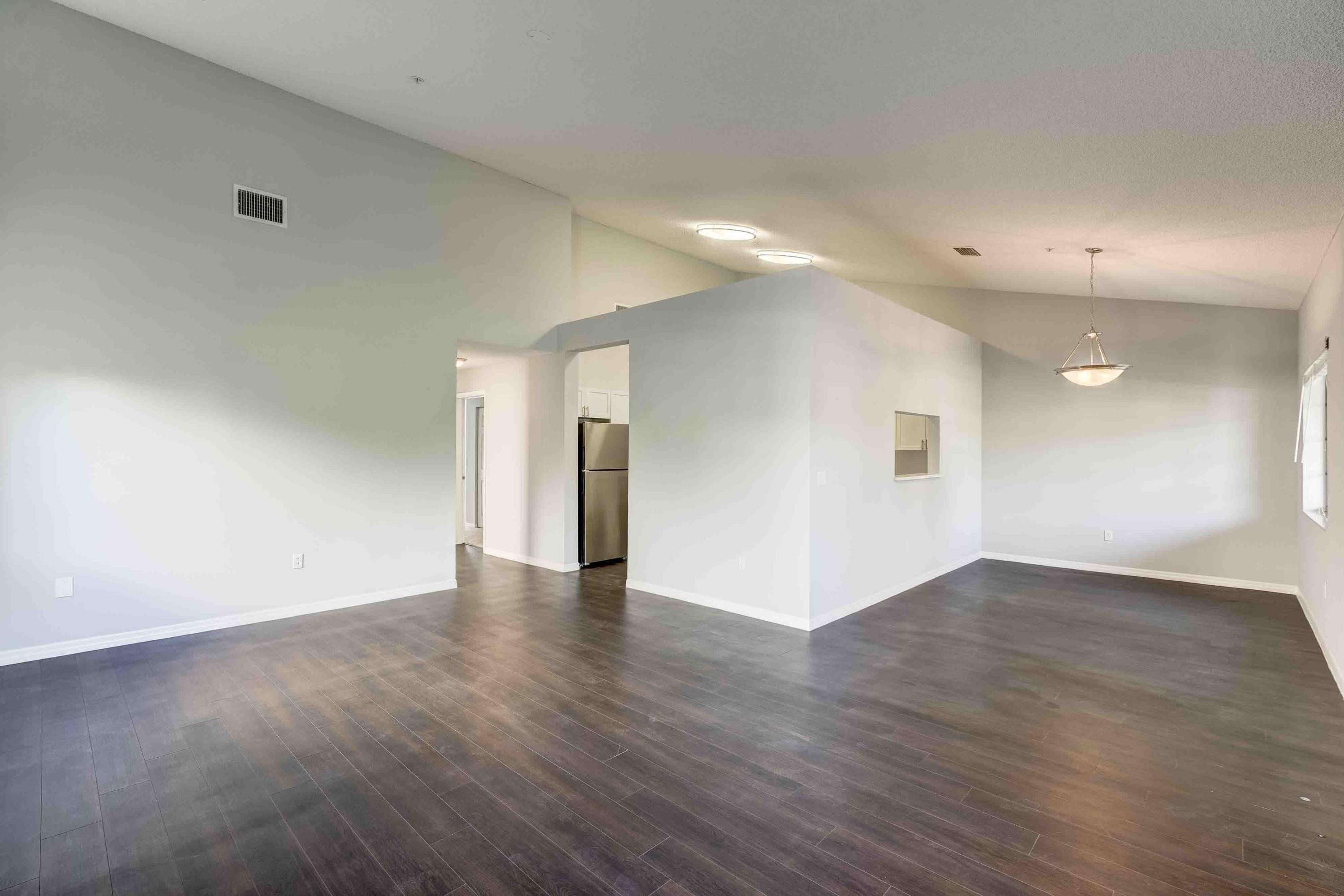4685 Haverhill Road, Unit C1 West Palm Beach, FL 33417 - Photo 6 of 37 an empty room with wooden floor and windows