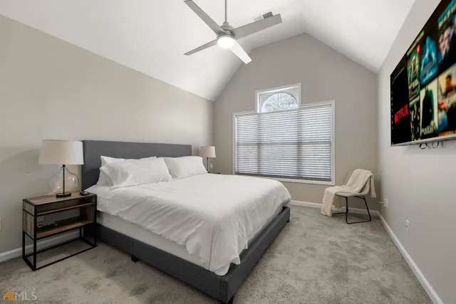 a bedroom with a bed a dresser and a large window