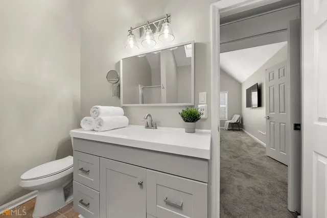 a view of bathroom with a toilet sink and mirror